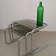 Nest tables in chrome metal and tinted glass.