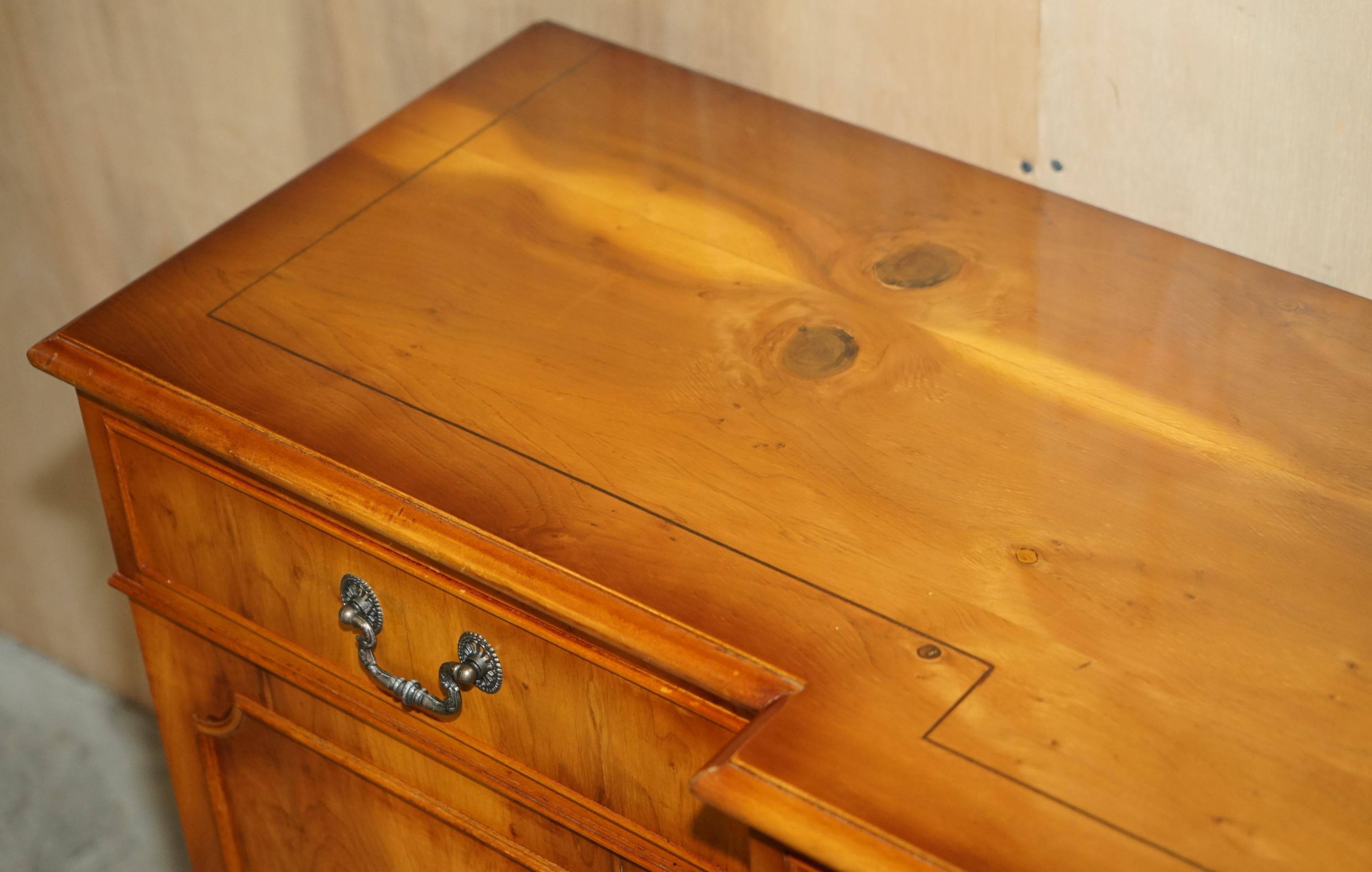 Vintage buffet made of mottled yew wood with three doors and four drawers.