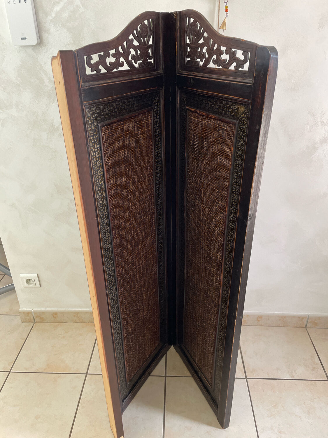 Antique wooden wall panel with carving and cane in an Asian style.