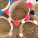 Moroccan basket with pale pink pompoms made of palm fiber