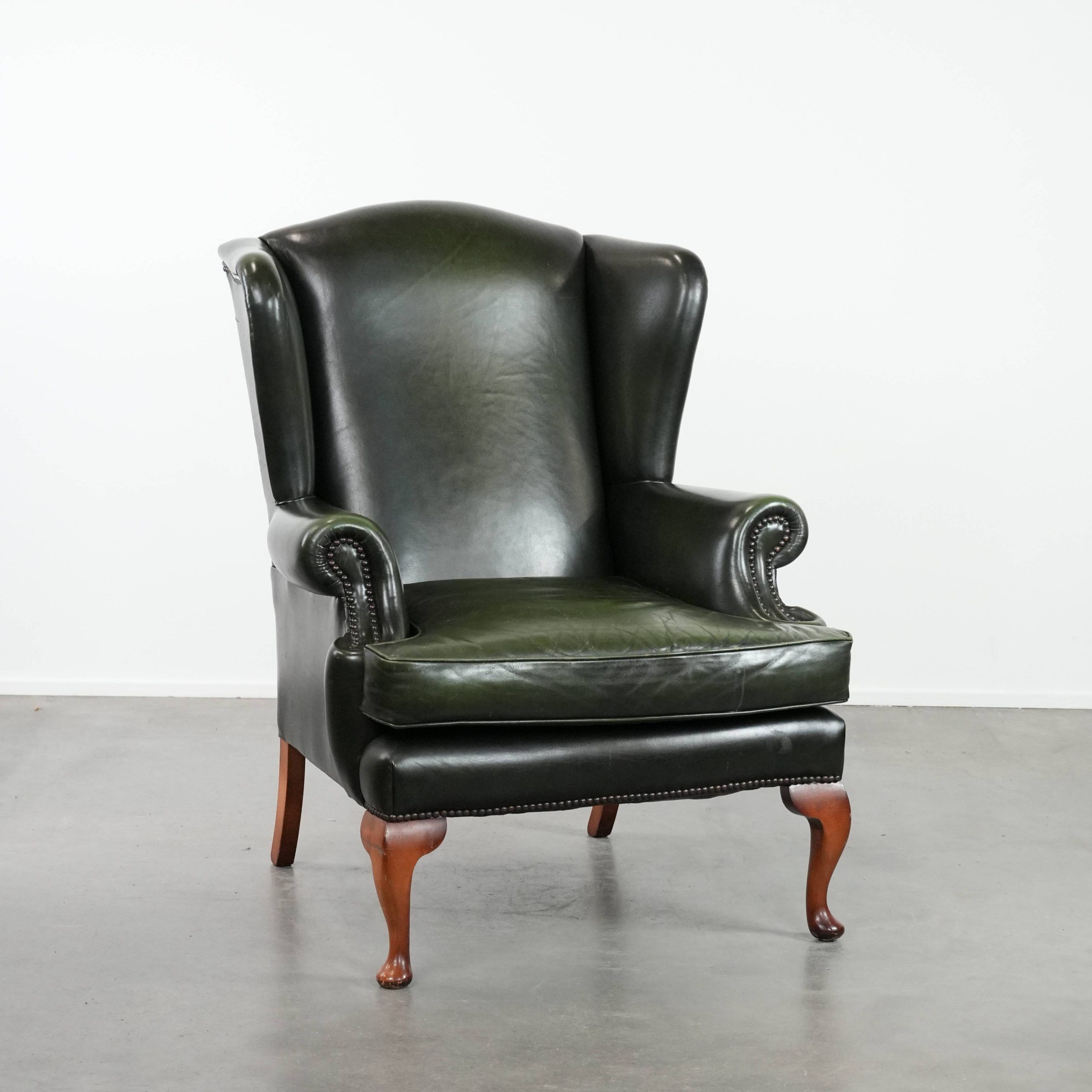 Smooth classic cowhide Chesterfield armchair in a stylish dark green color