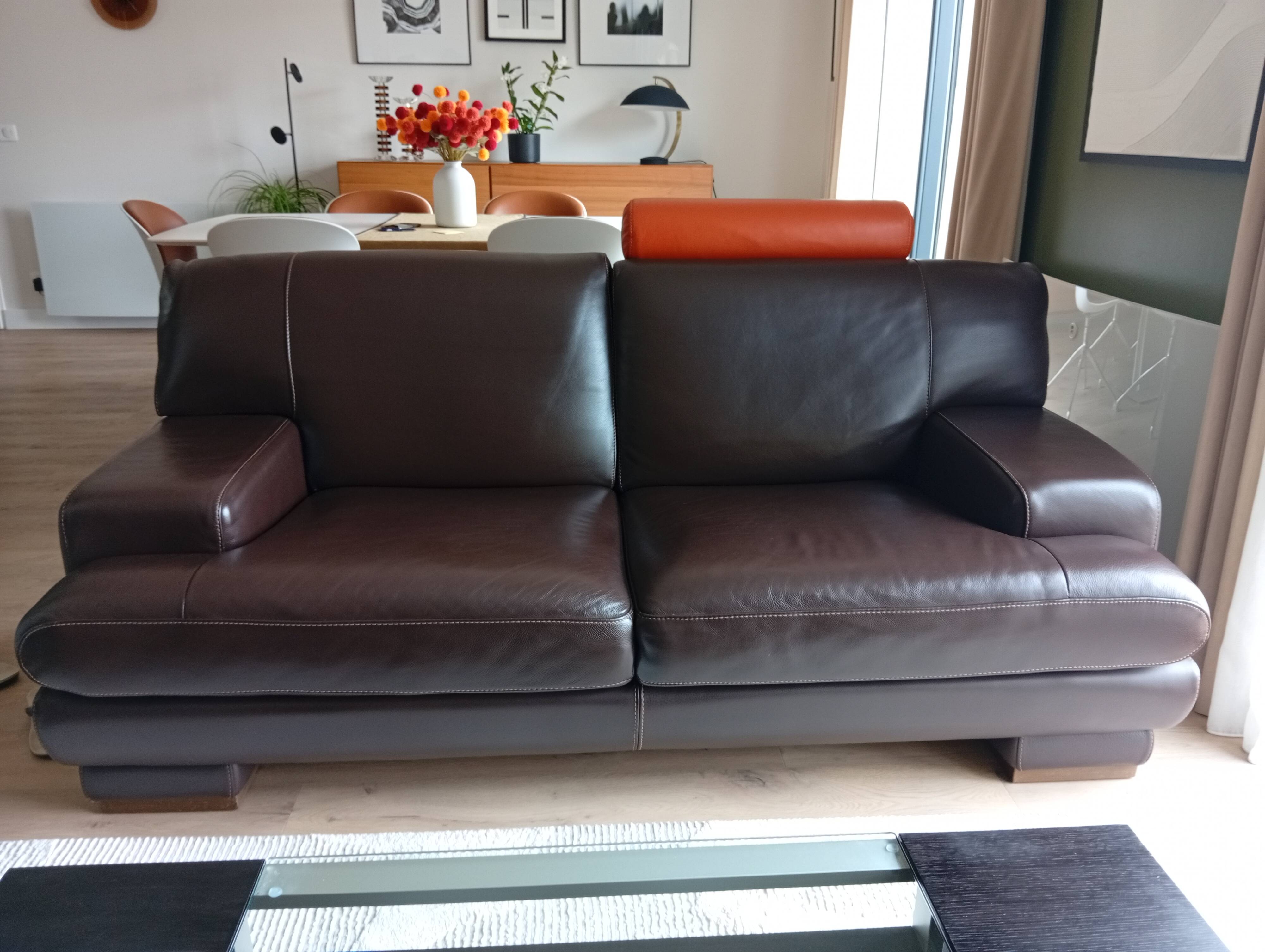 Two brown leather Crozatier two-and-a-half-seater sofas.