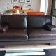 Two brown leather Crozatier two-and-a-half-seater sofas.