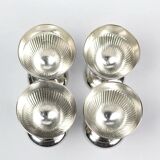 Four silver-plated Christofle egg cups with fluted sides.