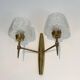 Pair of bronze wall sconces with worked glass reflectors. Stilnovo