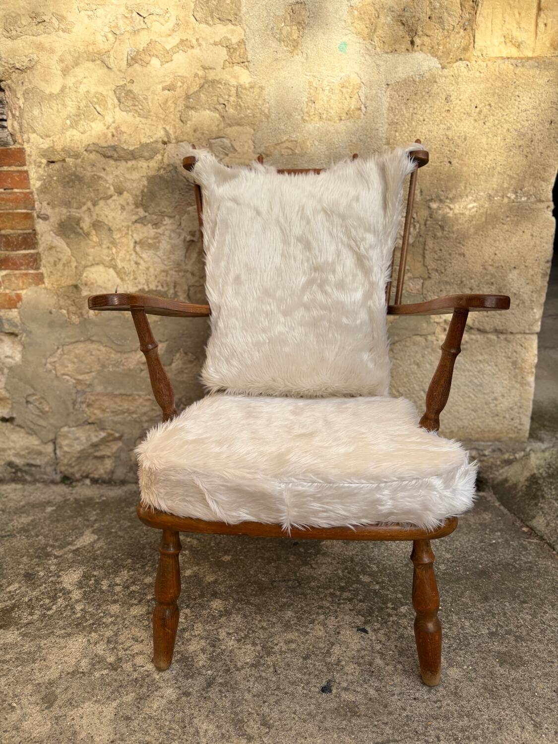 Scandinavian armchair in solid wood with beige fur cushion