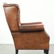 Sheepskin wingback armchair finished with black piping and a correct seat