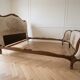 Double bed in Louis XVI style made of wood and floral fabric.