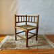 Antique corner chair by the fire with turned wood and straw seat.