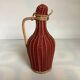 Small decorative bottle in burgundy wicker.