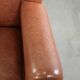 Fauteuil anglais à oreilles de couleur cognac clair en cuir de vache.