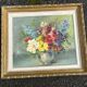 Still life of flowers in Impressionist style with a golden frame.