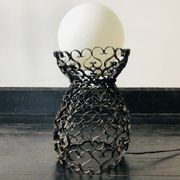 Black wrought iron lamp with a white glass globe.