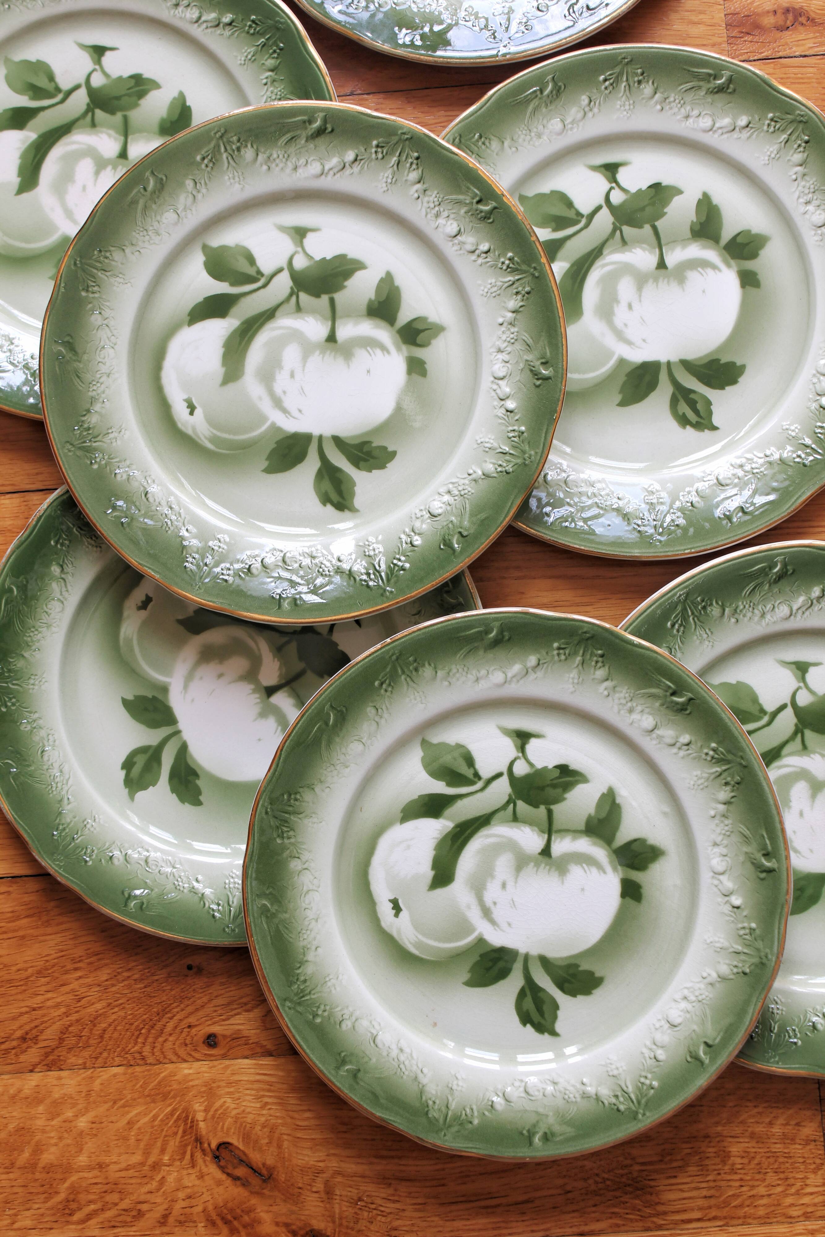 7 earthenware dessert plates with apple decoration and slip-brushed rim, KG Lunéville