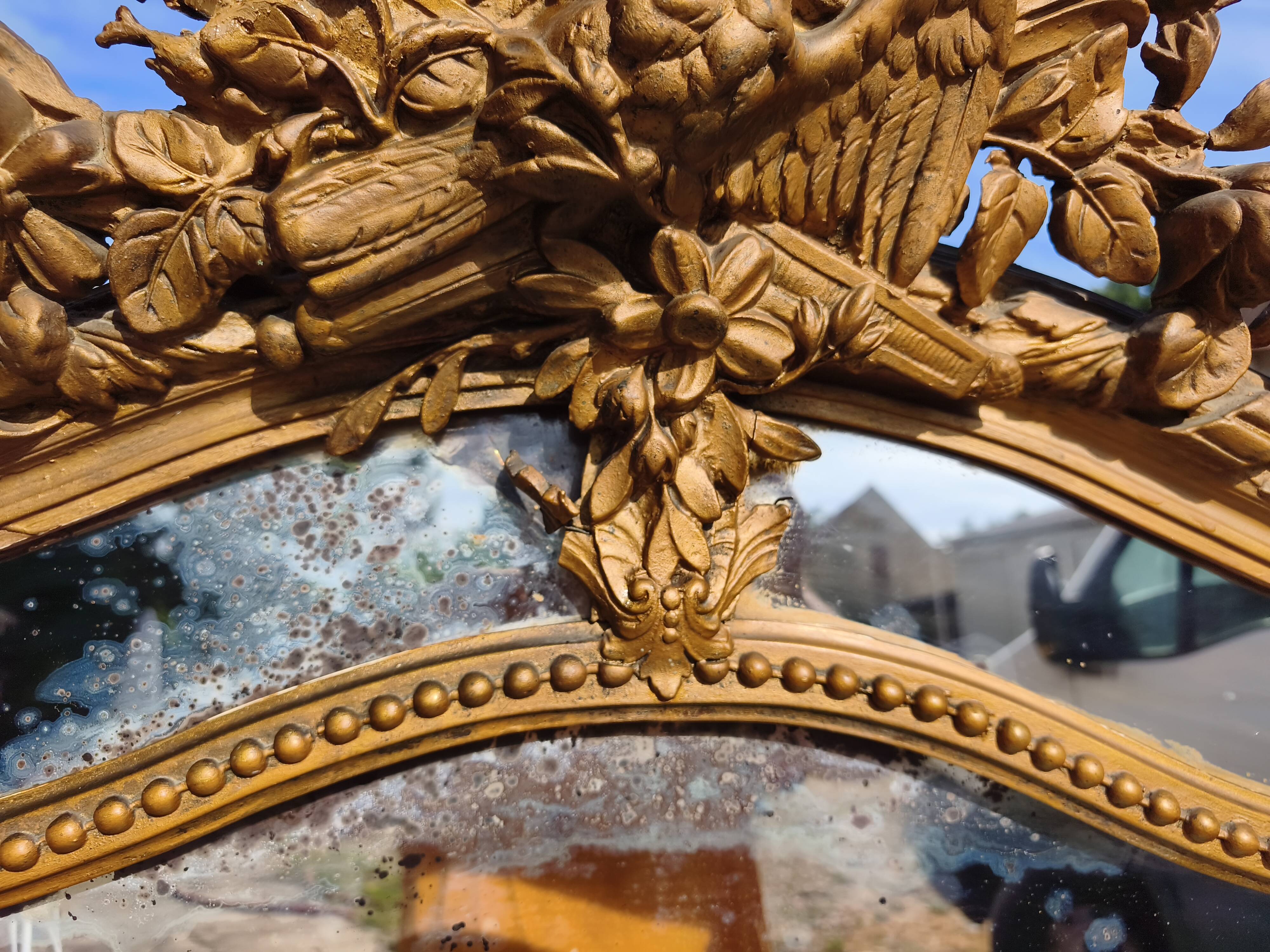 Large closed mirror, 19th century, wood and gilded stucco.