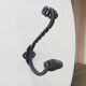 Brutalist wall coat rack in wrought iron.