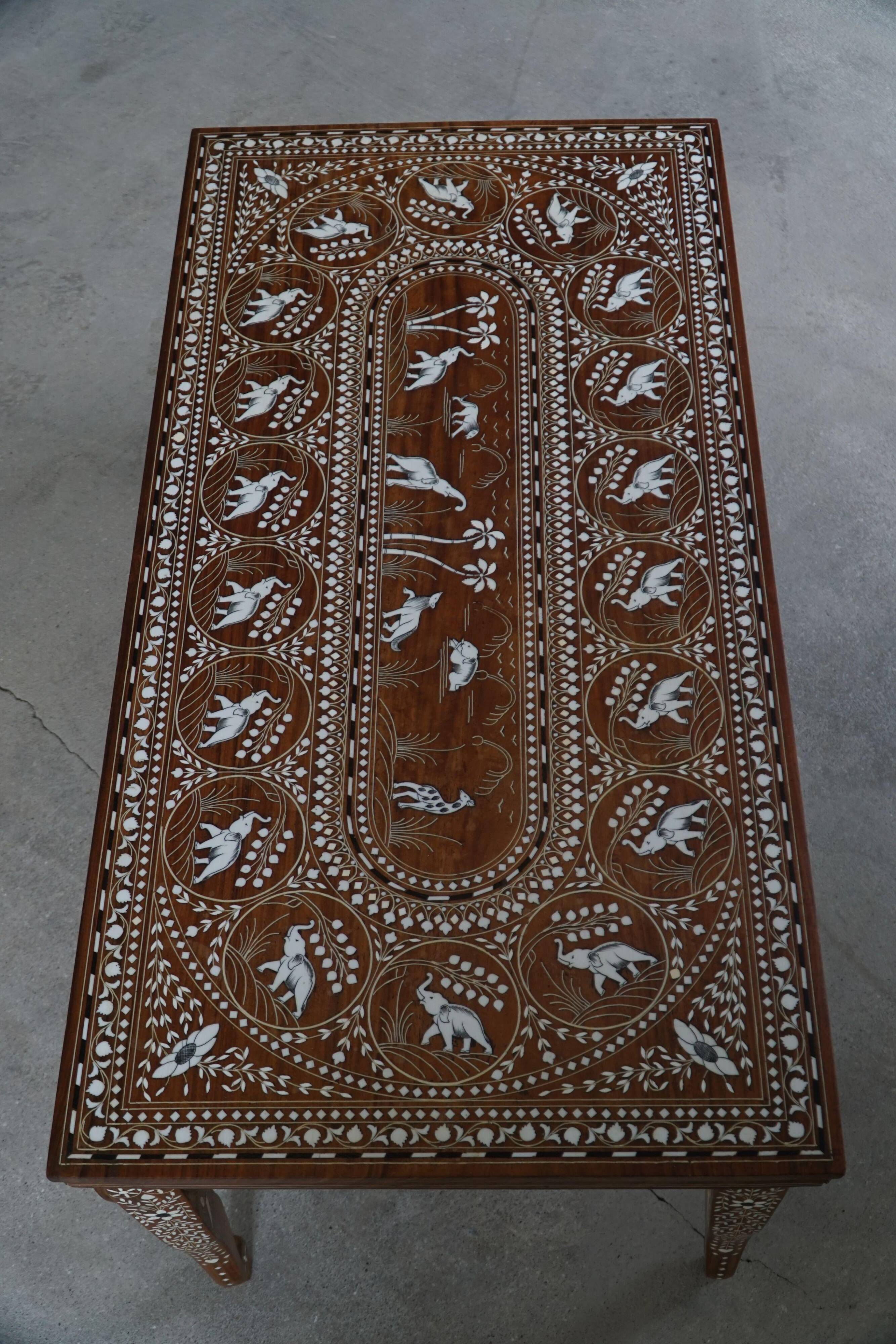 Vintage Indian teak coffee table inlaid with elephant motifs, mid-20th century.