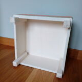 Low wooden stool painted in bright colours