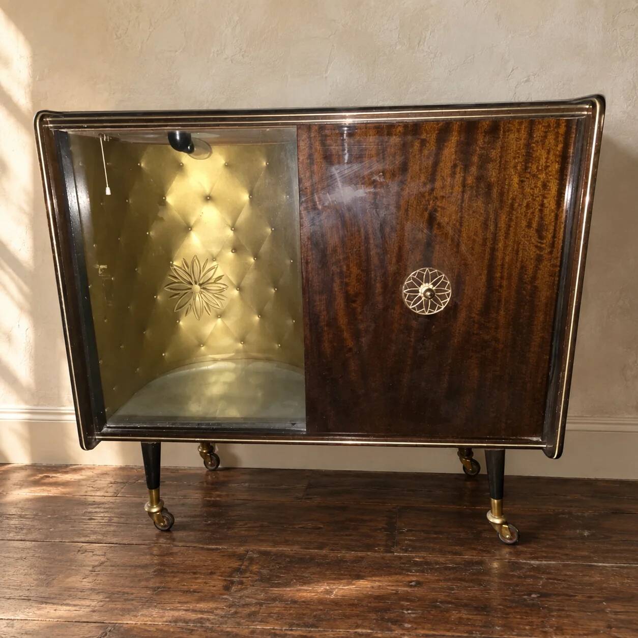 Vintage 50s-60s bar cabinet with tufted upholstery and lighting.