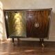 Vintage 50s-60s bar cabinet with tufted upholstery and lighting.