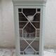 Vintage English corner display cabinet enhanced in grey-green with a wooden top.