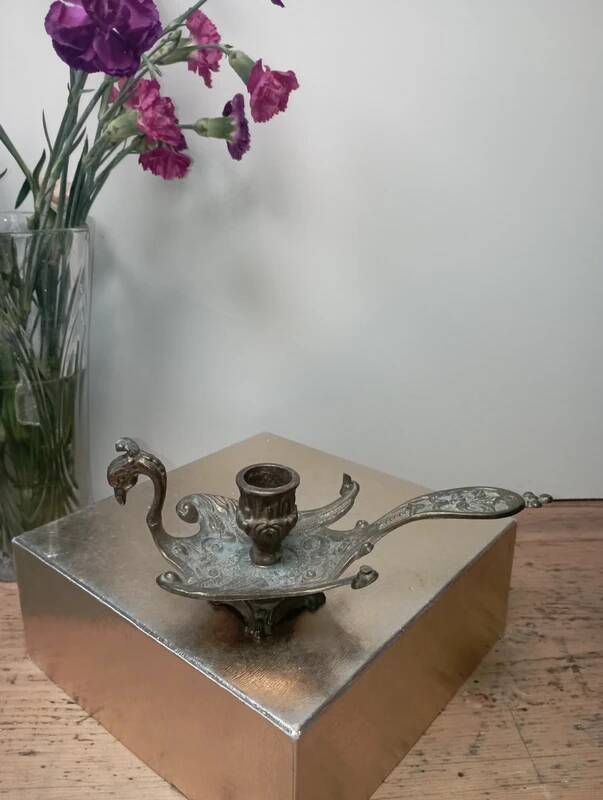 Chiselled brass candlestick in the shape of a peacock.