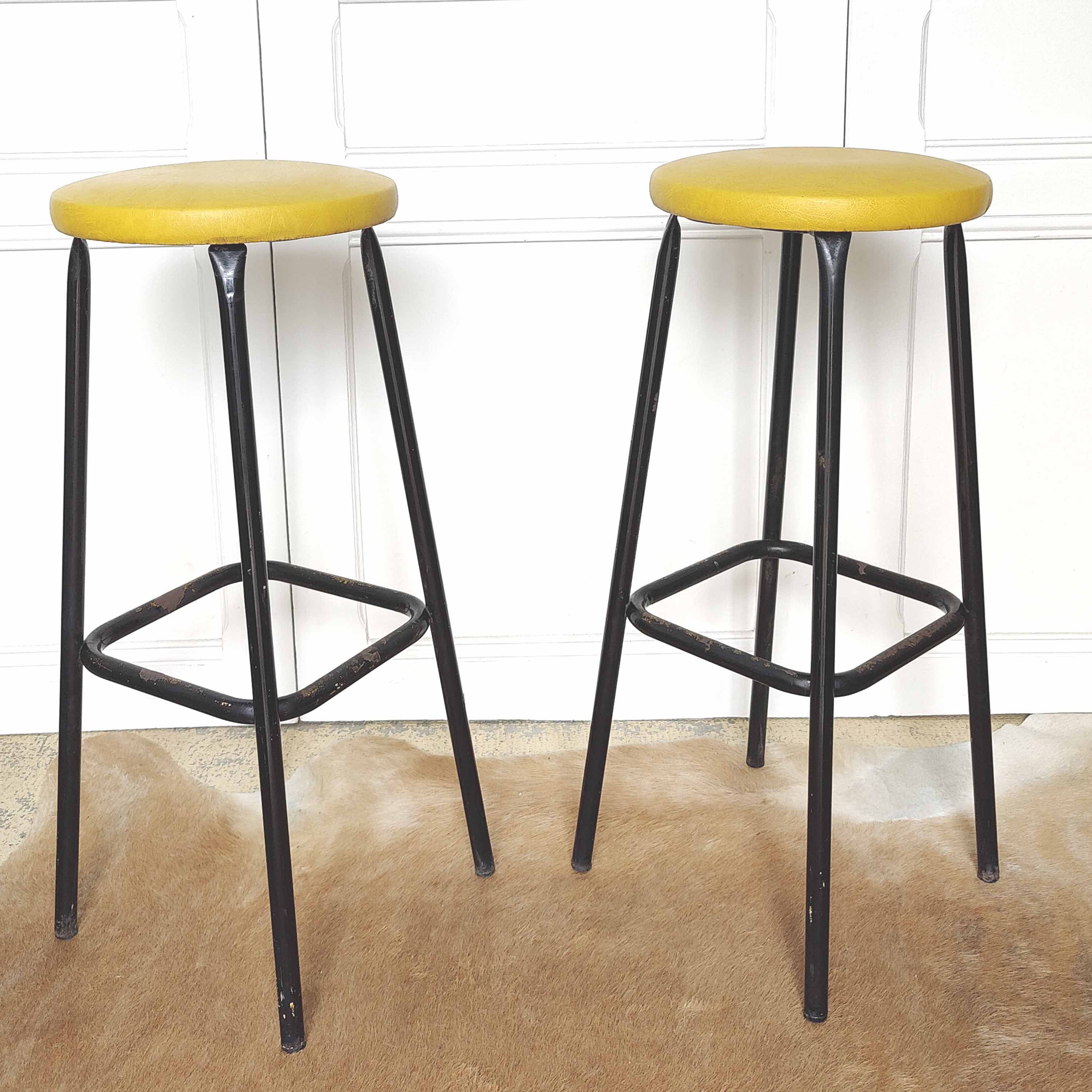 Pair of black metal bar stools and yellow imitation leather seat