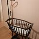 Old wooden rocking chair with turned legs and plumetis fabric.