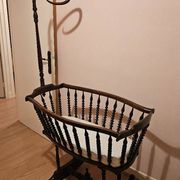 Old wooden rocking chair with turned legs and plumetis fabric.