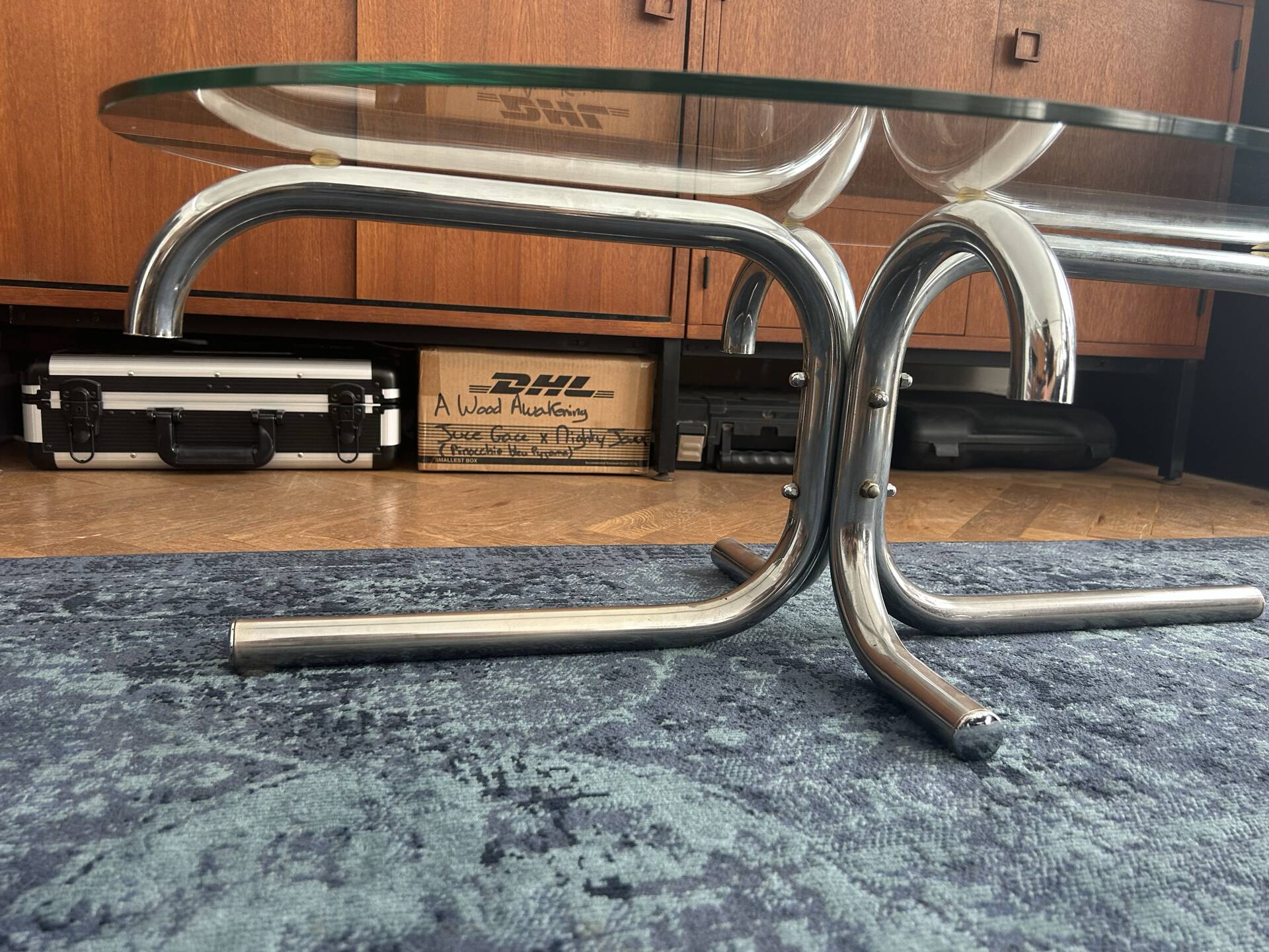 Oval glass coffee table with chrome legs, vintage 70s design.