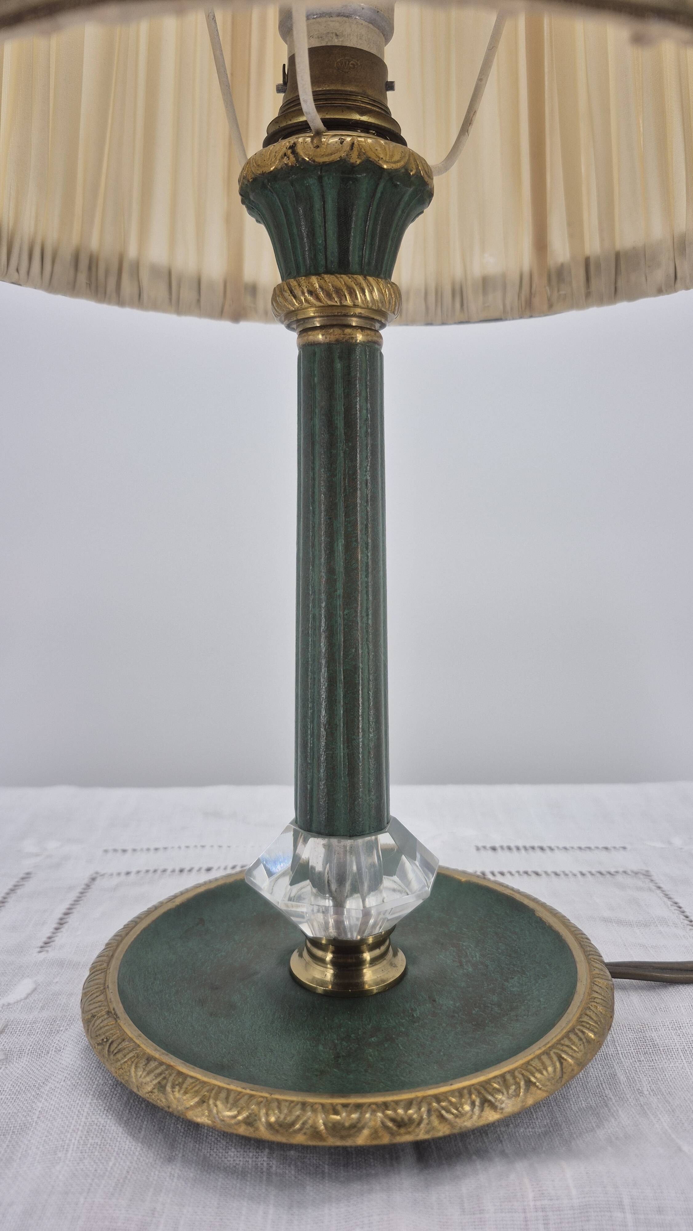 Brass table lamp with green patina and empire-style fabric shade.