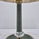 Brass table lamp with green patina and empire-style fabric shade.