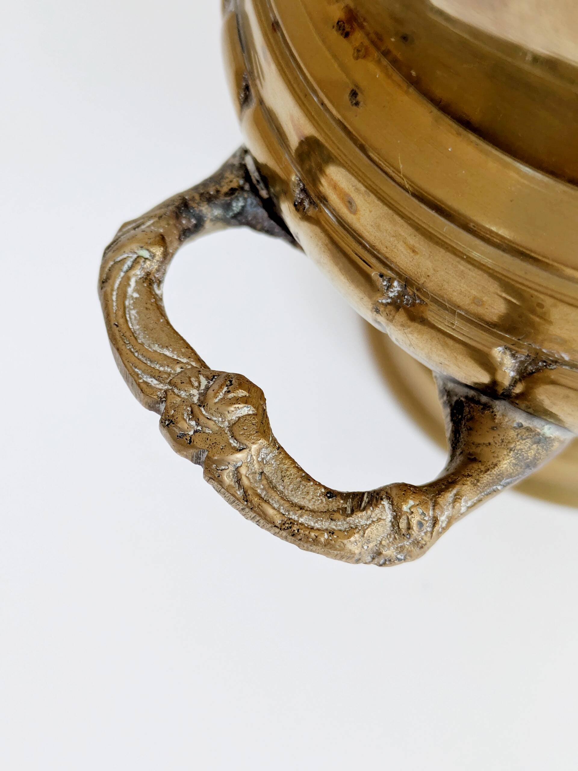 Vintage brass cache-pot on a stand with handles, classic decor.