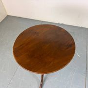Round coffee table with an adjustable top in antique mahogany.