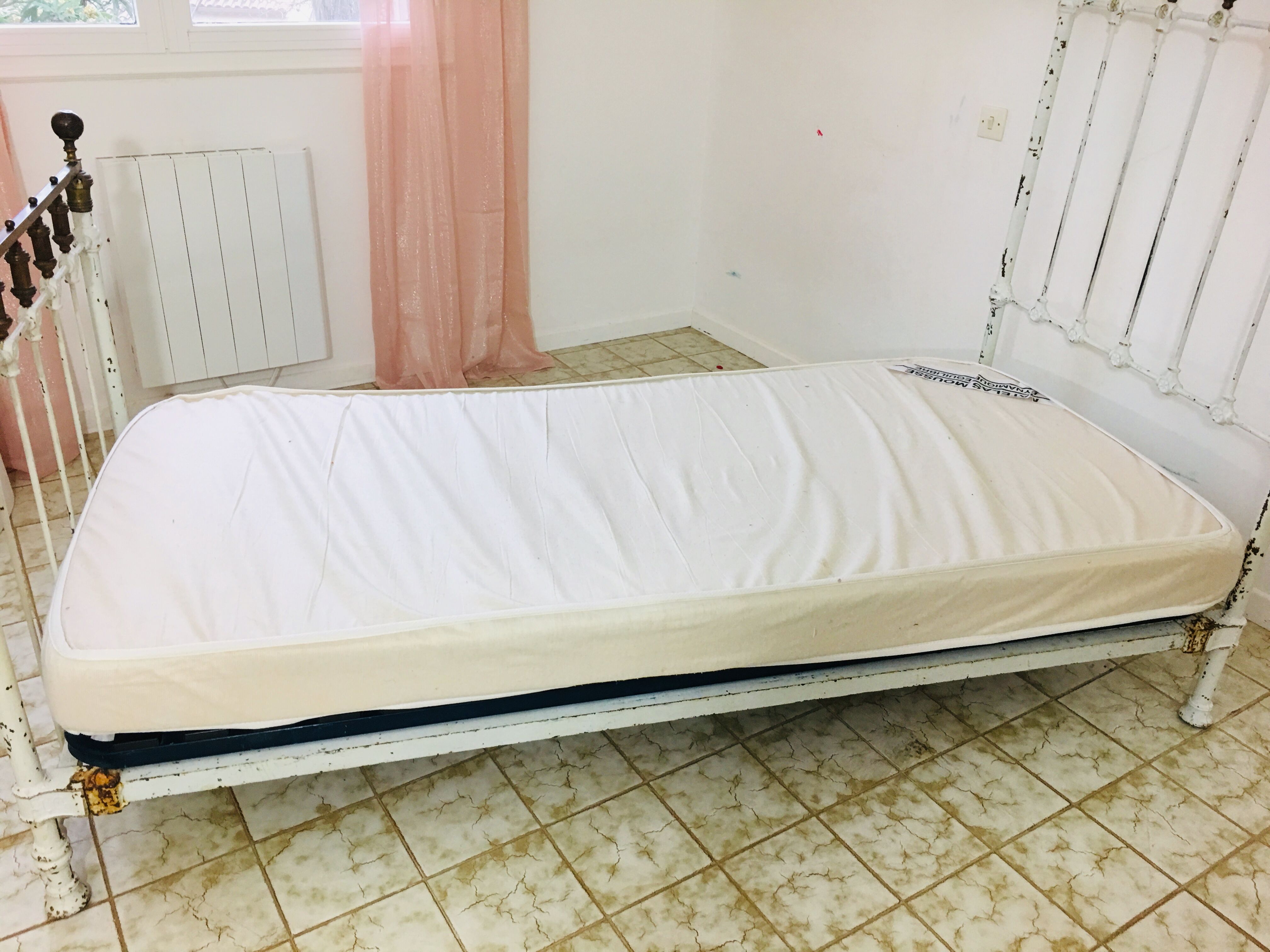 Old white metal and brass bed