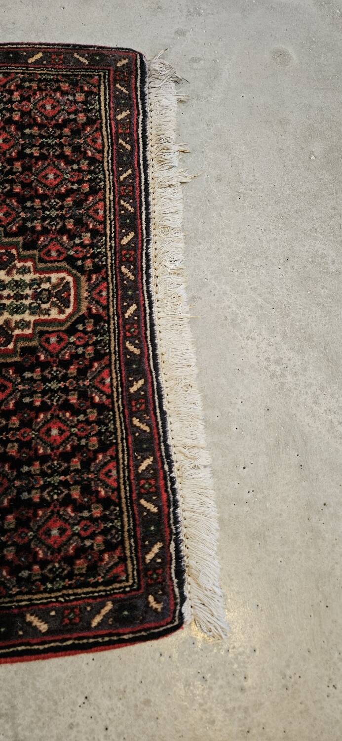 Ancient Persian carpet, wool, red tones, hand-knotted.