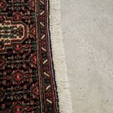 Ancient Persian carpet, wool, red tones, hand-knotted.