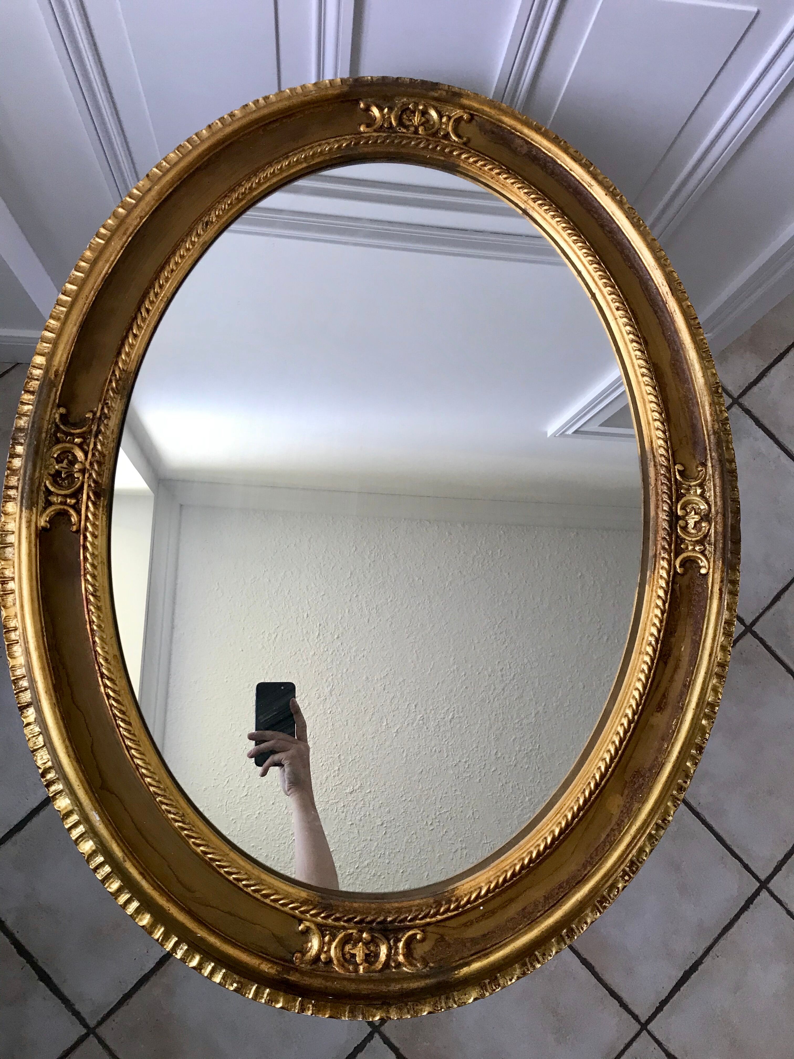Grand miroir oval en stuc doré vintage