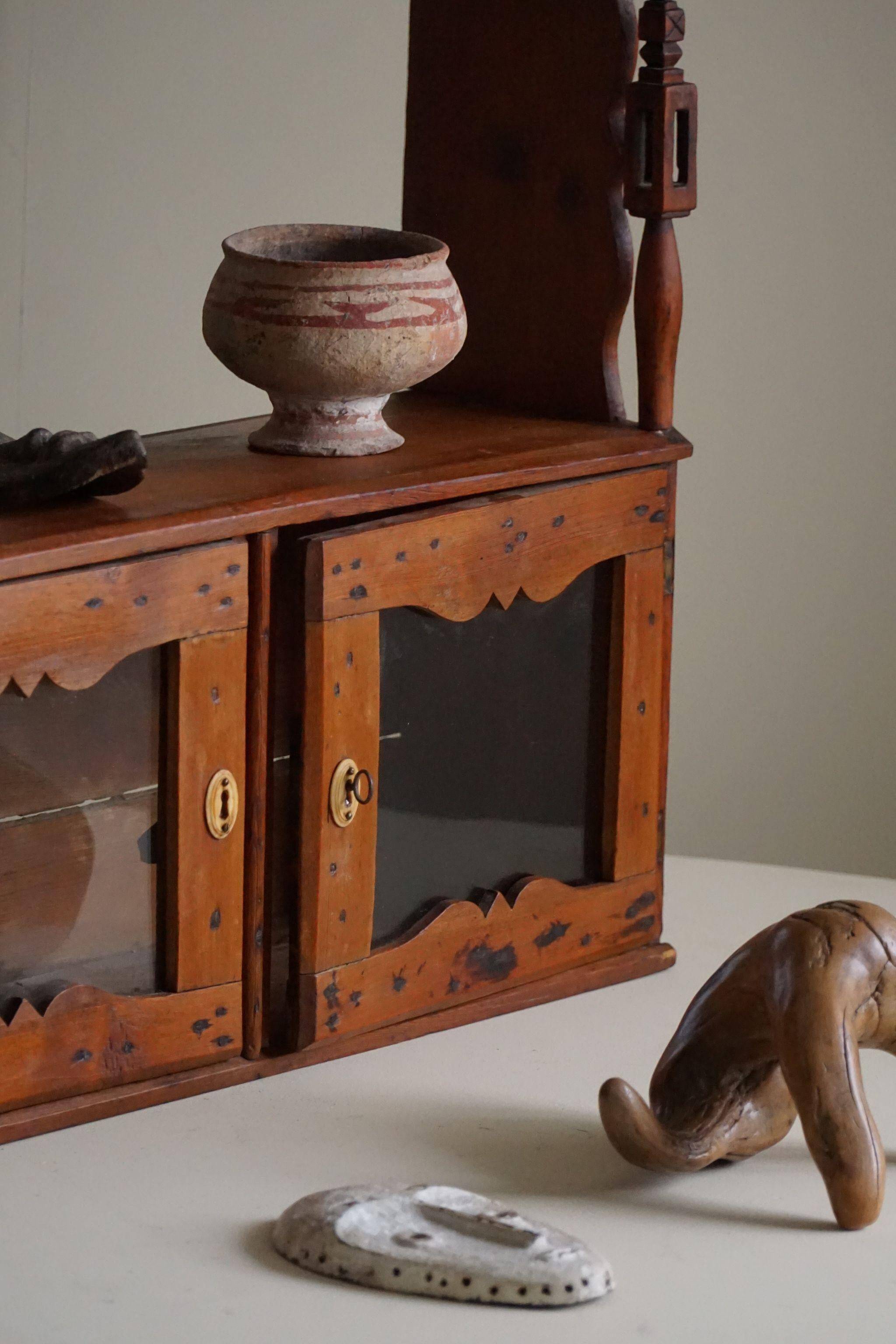 Primitive wall shelf in pine, by a Swedish upholsterer, late 19th century.