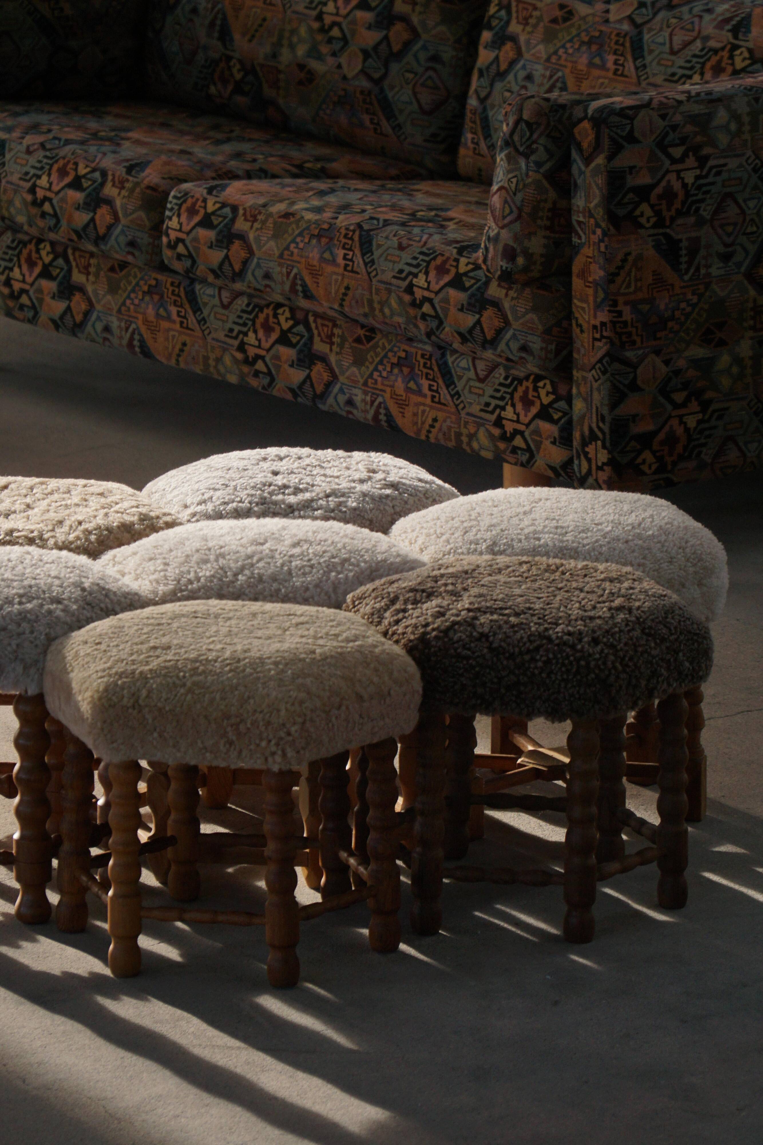 Pair of mid-century Danish oak stools with shearling lambswool upholstery, 1950s.