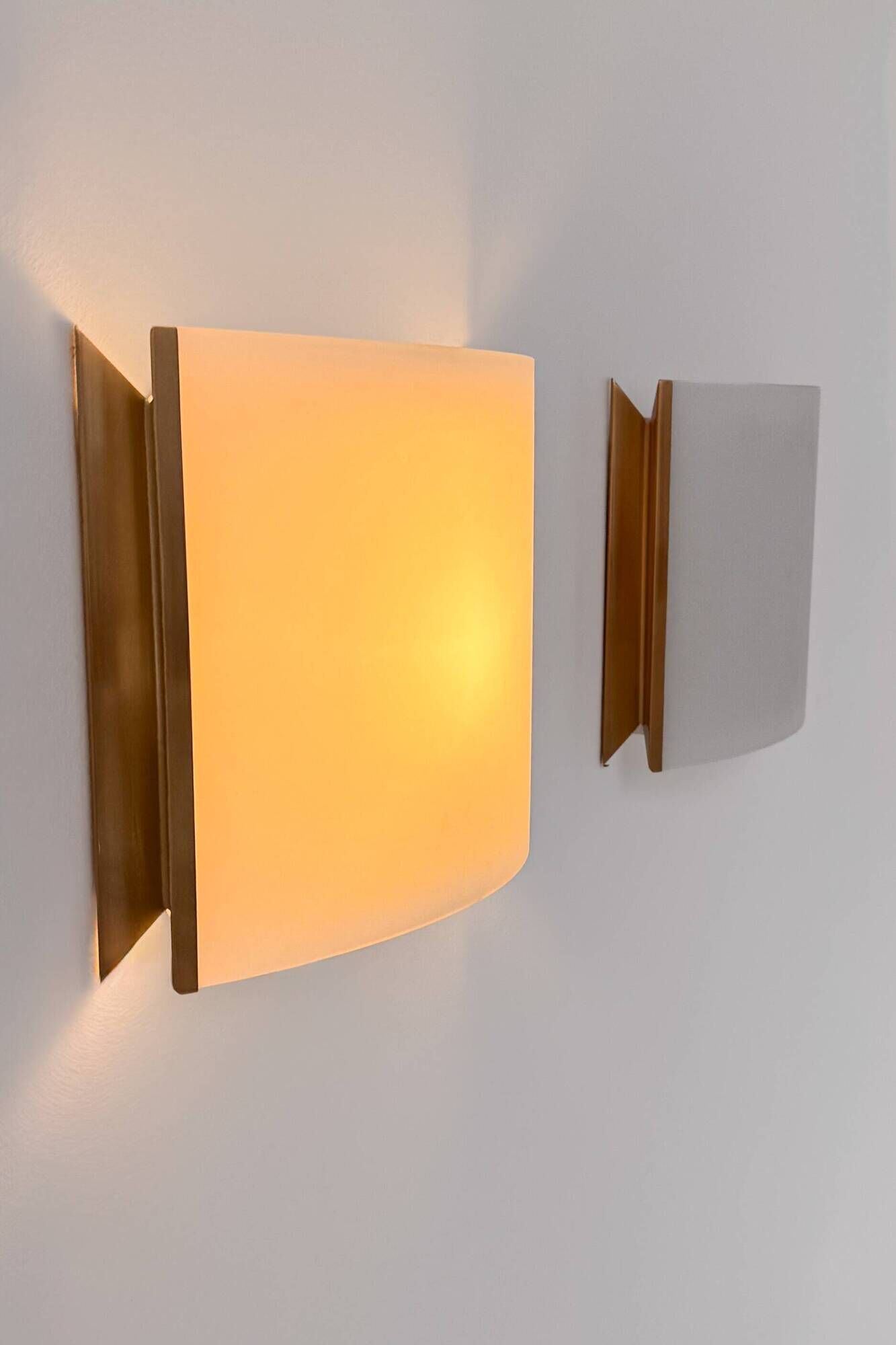 Pair of vintage brass and curved glass wall lights, France, 1970.