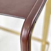 Contemporary kitchen bar stool in aged brass metal and navy blue leather.