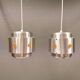Two Space-Age hanging lamps, in silver-coloured aluminium with orange prisms.