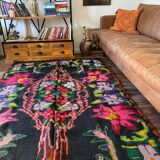 Bohemian floral design, handwoven wool rug, black background with colorful flowers