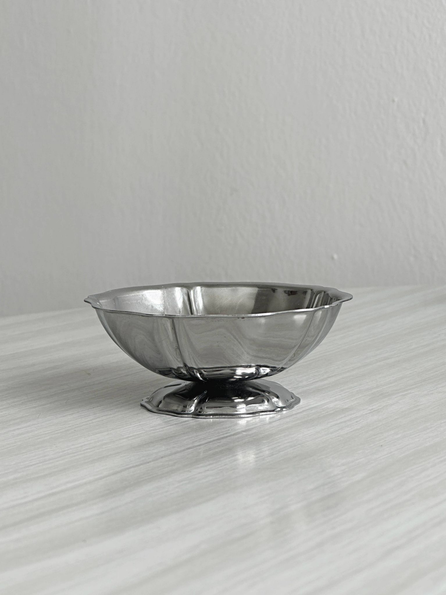 Set of 9 low bowls in shiny stainless steel.