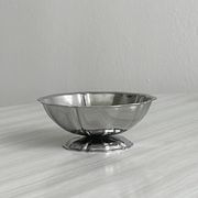 Set of 9 low bowls in shiny stainless steel.