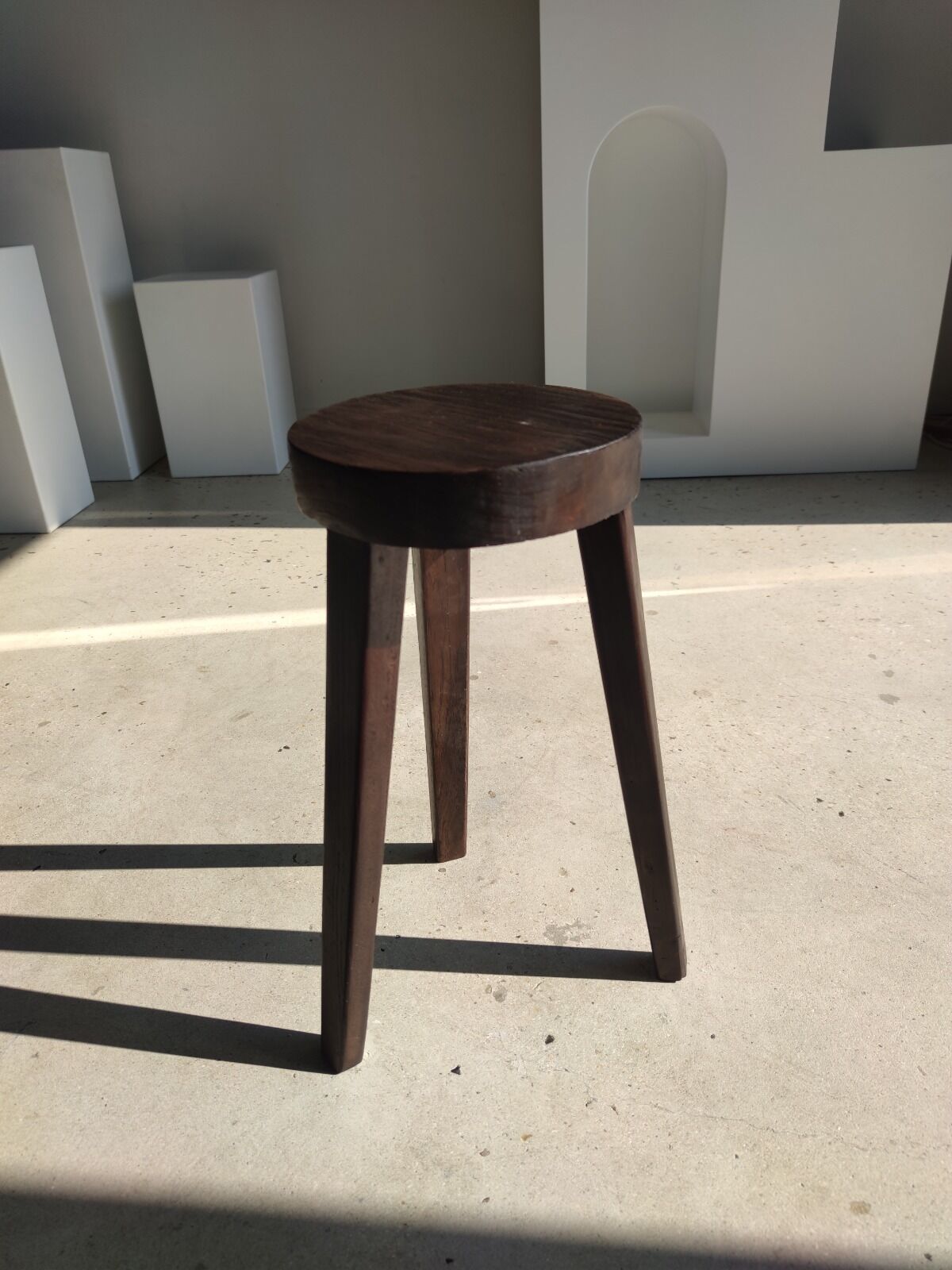 Small high tripod stool in brown solid wood