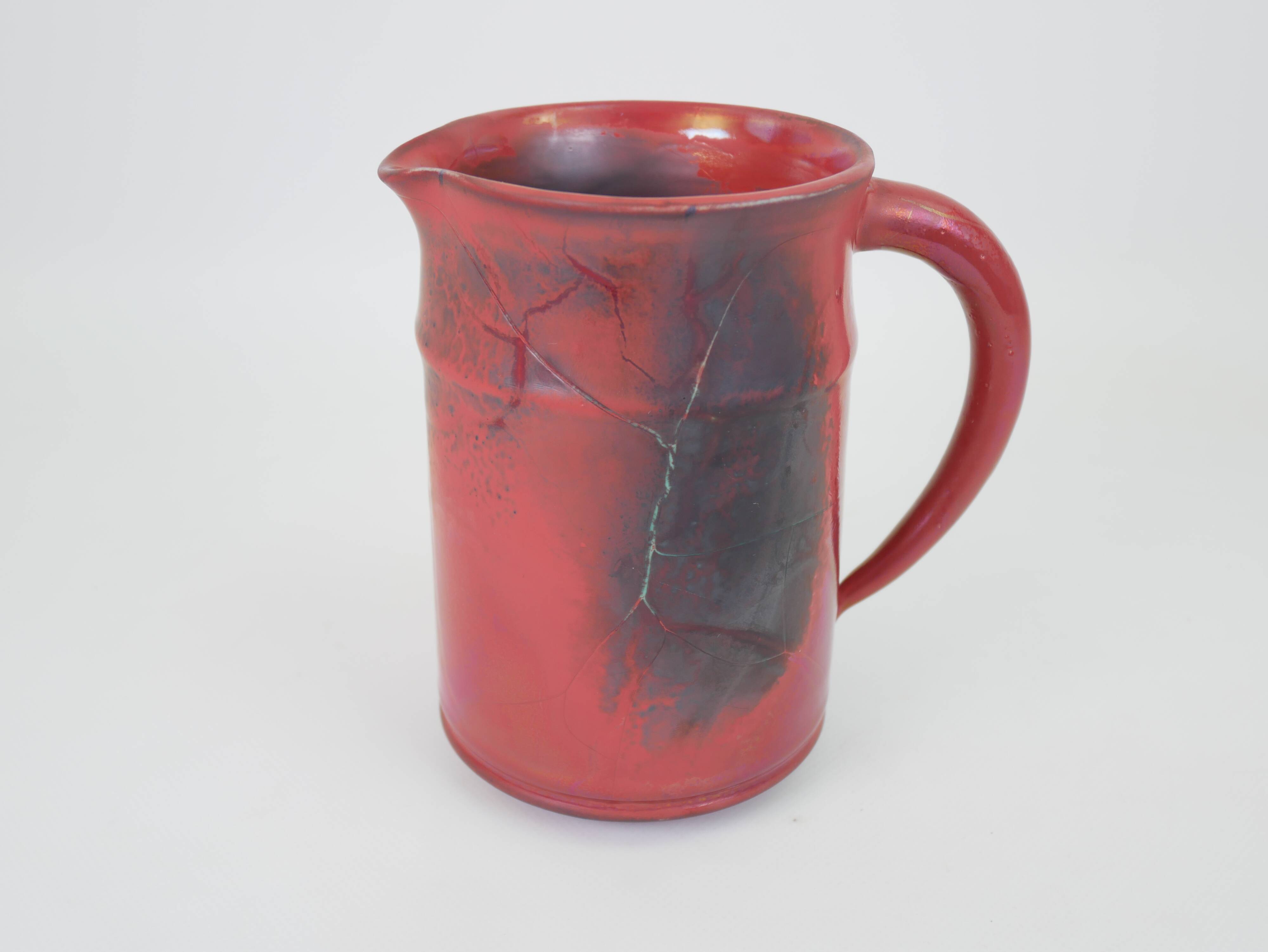 Red glazed ceramic jug with relief