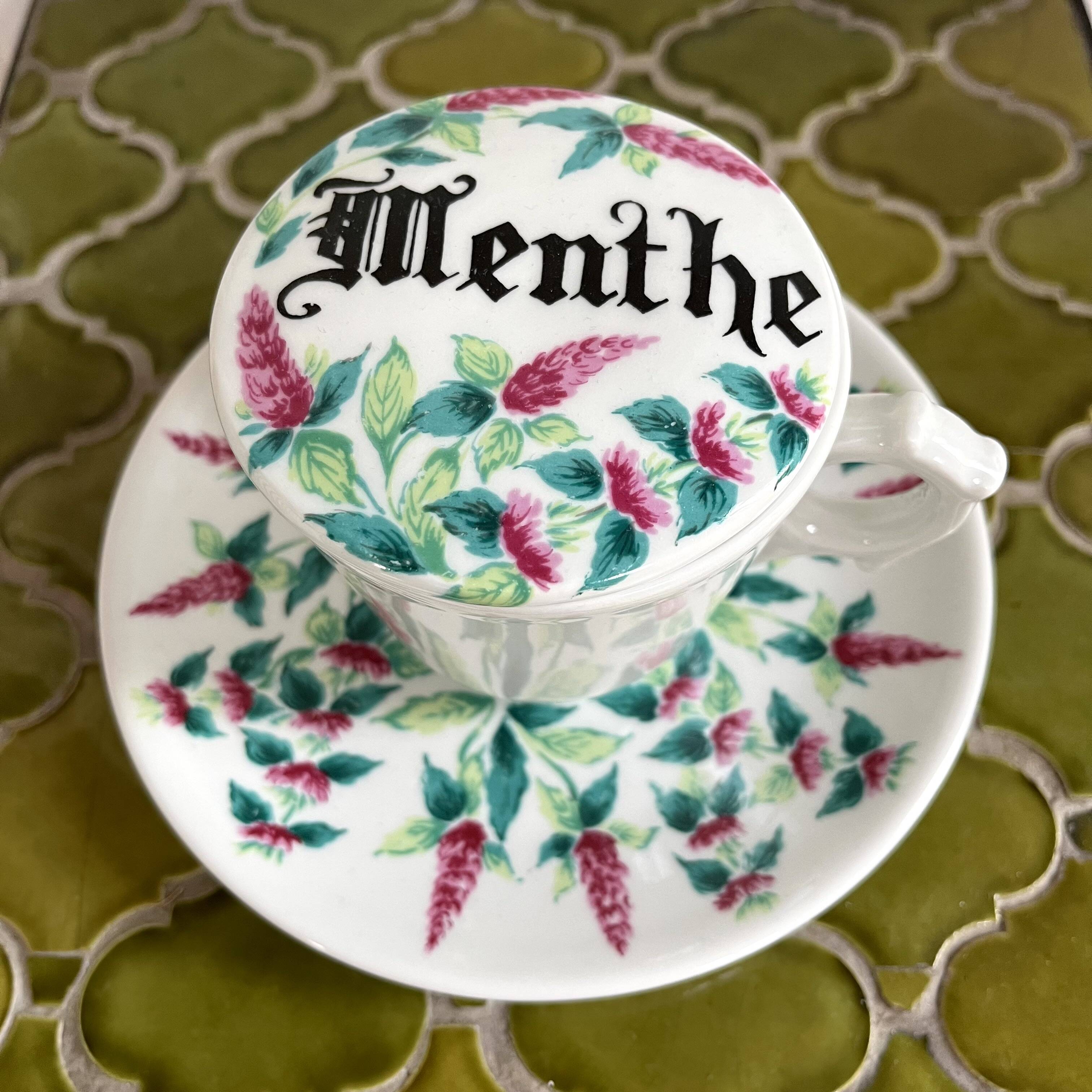 Antique herbal tea cup with mint infusion