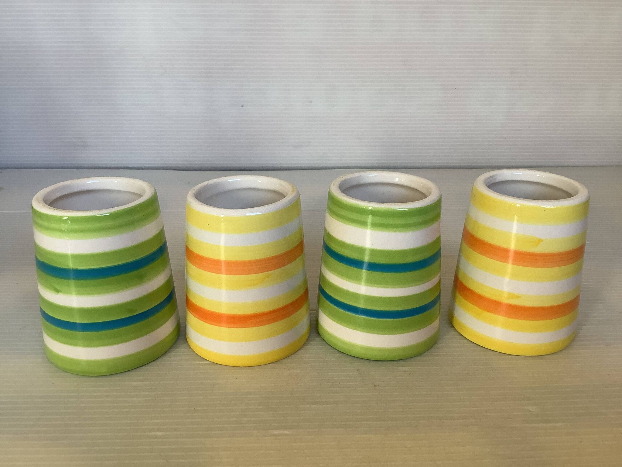 Four striped egg cups in yellow and green.